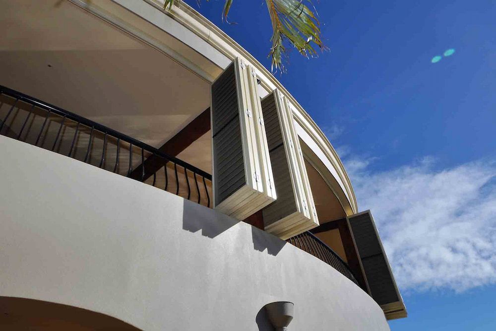 A White Building With A Balcony And A Blue Sky In The Background — Balcony Shutters Australia In Moffat Beach, QLD