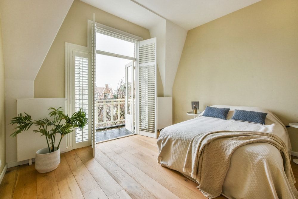 A Bedroom With A Large Bed And A Balcony — Balcony Shutters Australia In Moffat Beach, QLD