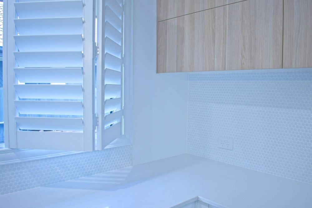 A Bathroom With A Bathtub And A Window With Shutters — Balcony Shutters Australia In Moffat Beach, QLD