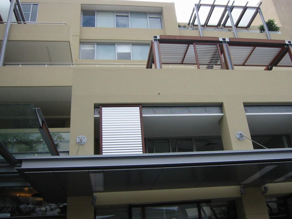 A Large Building With Lots Of Windows And Balconies — Balcony Shutters Australia In Moffat Beach, QLD