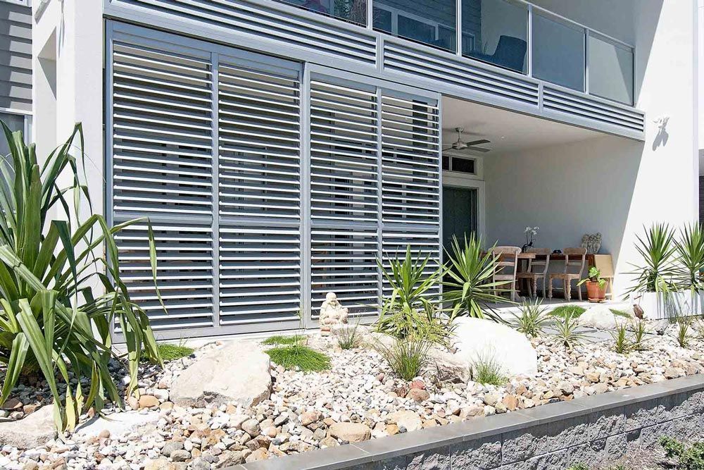 A House With A Balcony And A Sliding Glass Door — Balcony Shutters Australia In Moffat Beach, QLD