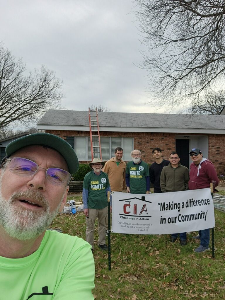 Group holding a “Making a difference in our community” banner at an outdoor volunteer event