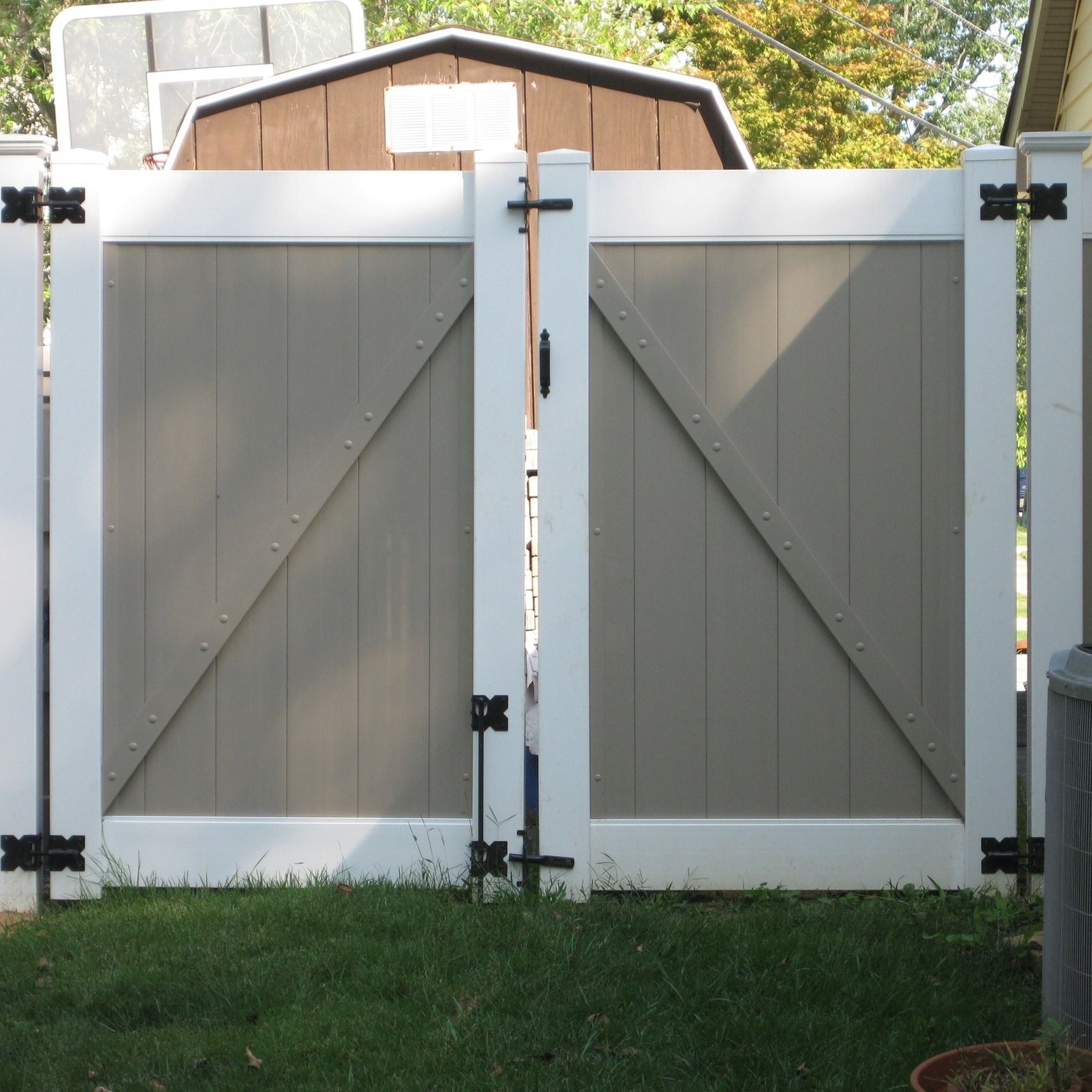 A white fence with a shed in the background