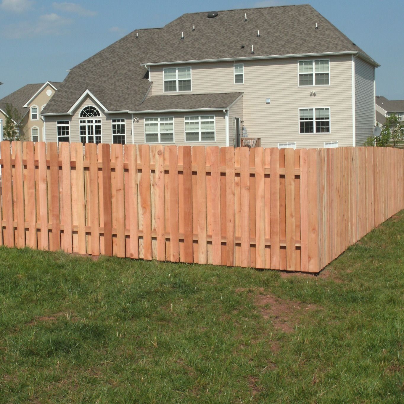 A large house with a wooden fence in front of it