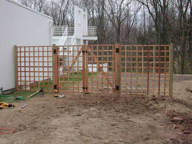 A wooden gate is being built in front of a white building