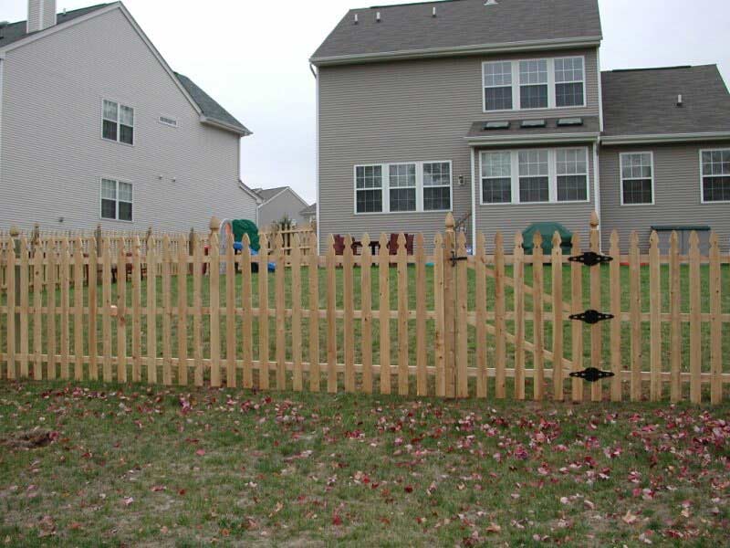 A wooden picket fence in front of a house