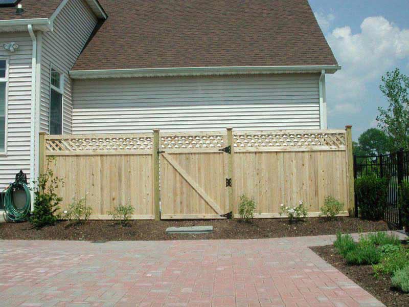 A wooden fence with a gate in front of a house