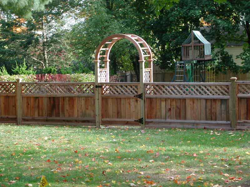A wooden fence with an arch in the middle of it
