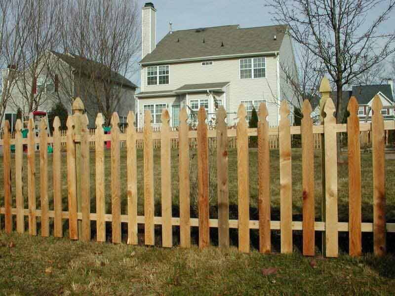 A wooden picket fence in front of a house