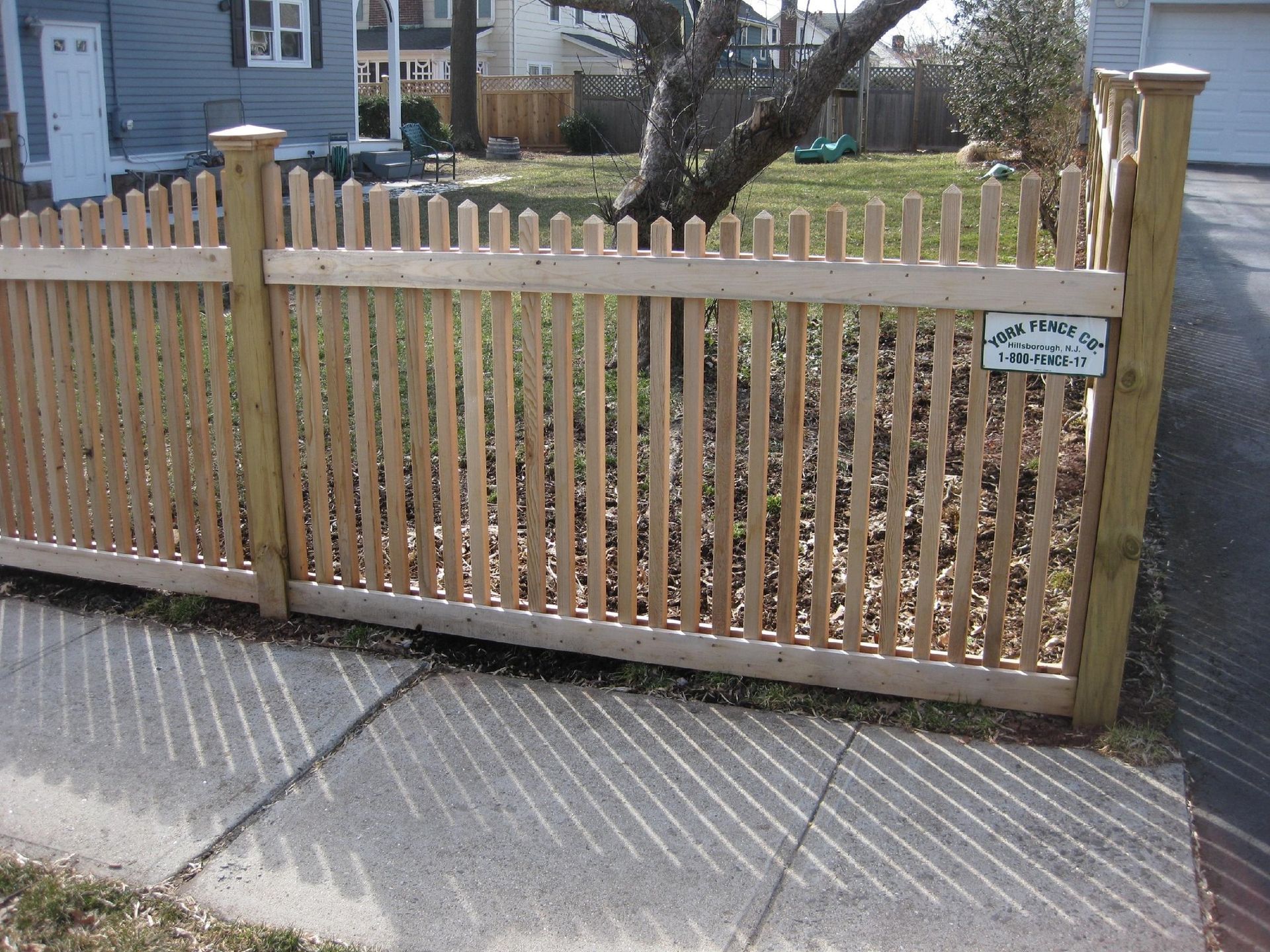 A wooden picket fence with a sign on it