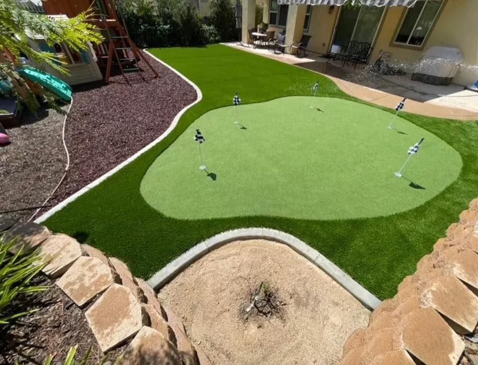 Backyard with putting green, artificial grass, and play area.