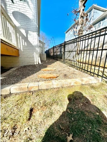 A large house with a garage and a driveway on a rainy day.