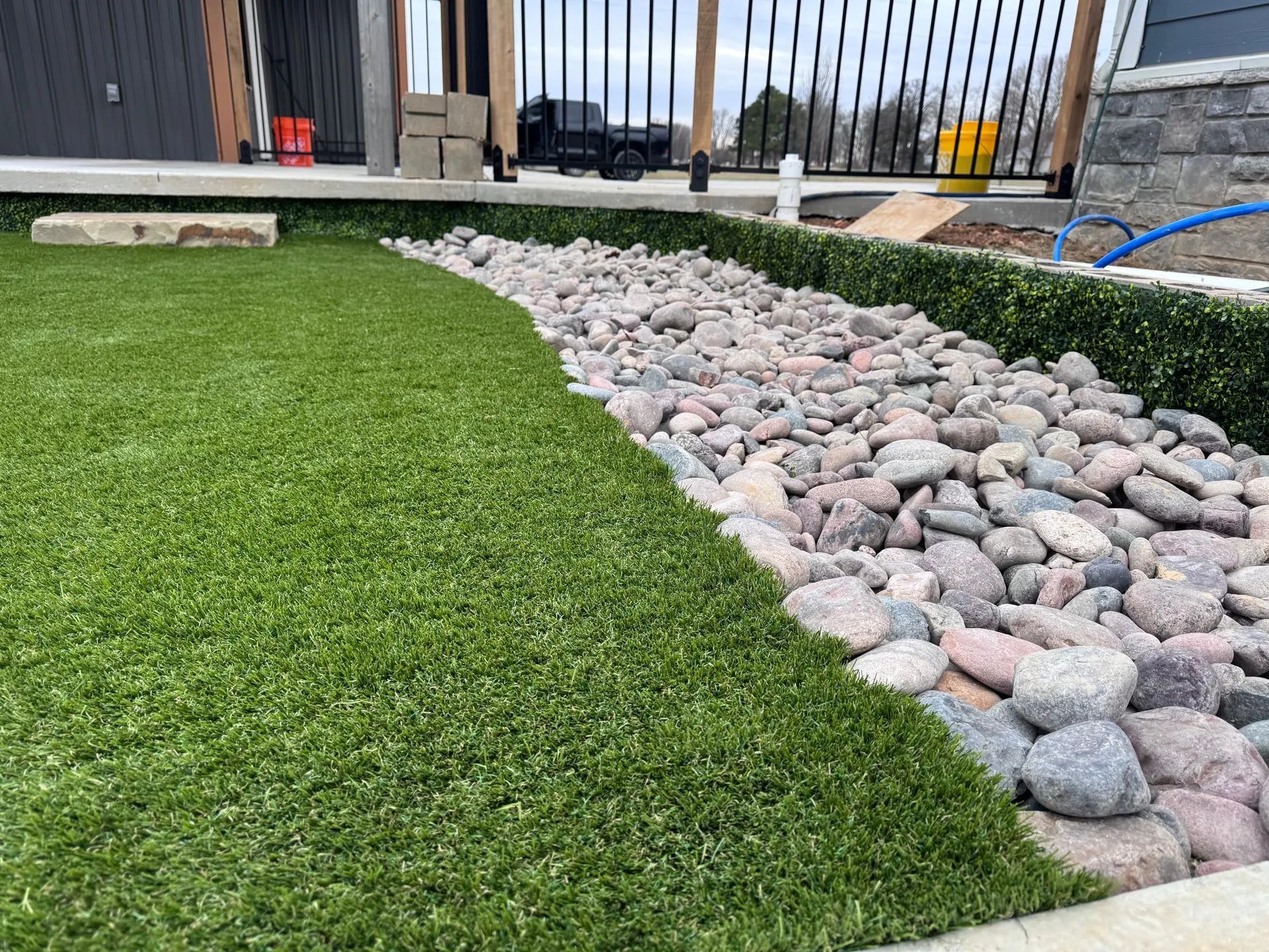 Green turf and rock bed border a modern home's exterior.
