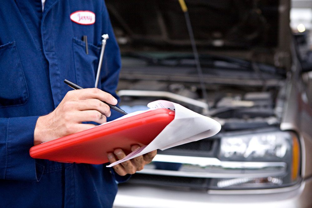Mechanic Writing Car Servicing Repair On The Clipboard — Torque Masters Auto Repairs Centre In Portsmith QLD