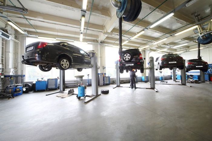 Four black cars on lifts in small service station — Motor Mechanics in Port Macquarie, NSW