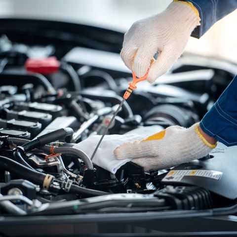 A Man Is Holding A Wrench In Front Of A Car With The Hood Open — APPS Mechanical Port Macquarie In Port Macquarie, NSW