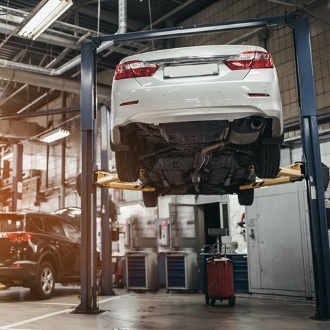 A Car Is Sitting On A Lift In A Garage — APPS Mechanical Port Macquarie In Port Macquarie, NSW