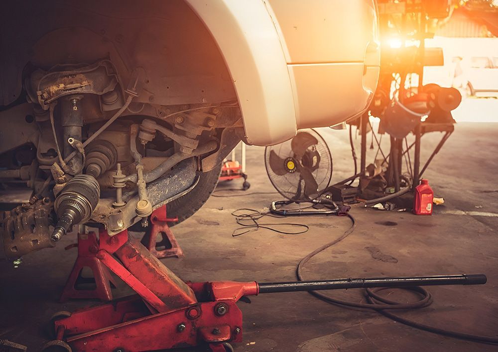 Car Raised on a Jack in a Garage, Wheel Removed