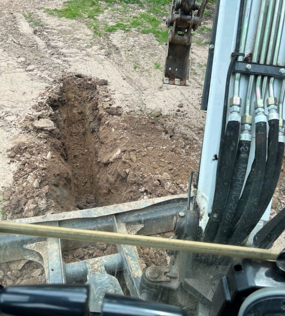 A machine is digging a hole in the ground.