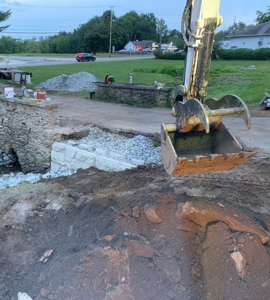 A yellow excavator is digging a hole in the ground.