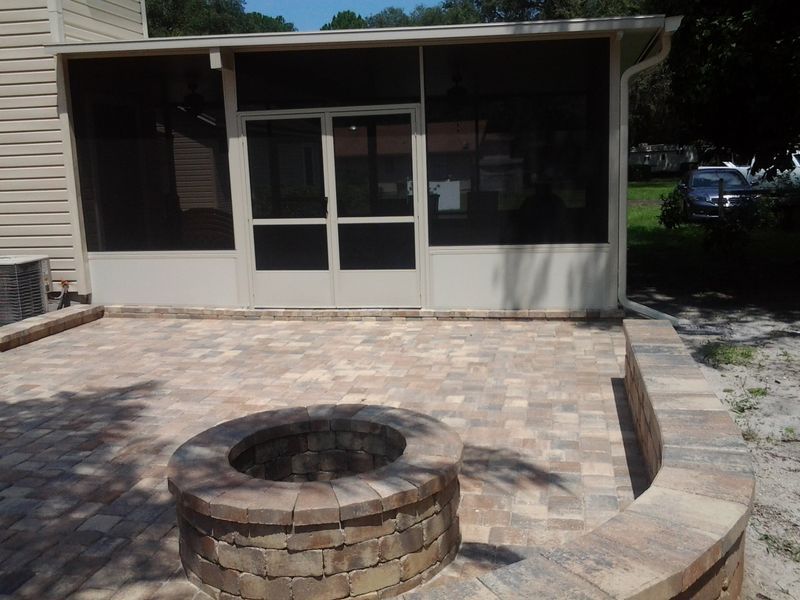 Brick patio with fire pit and screened porch.