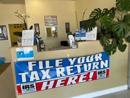 Tax office counter with banner reading “FILE YOUR TAX RETURN HERE!” and IRS signs