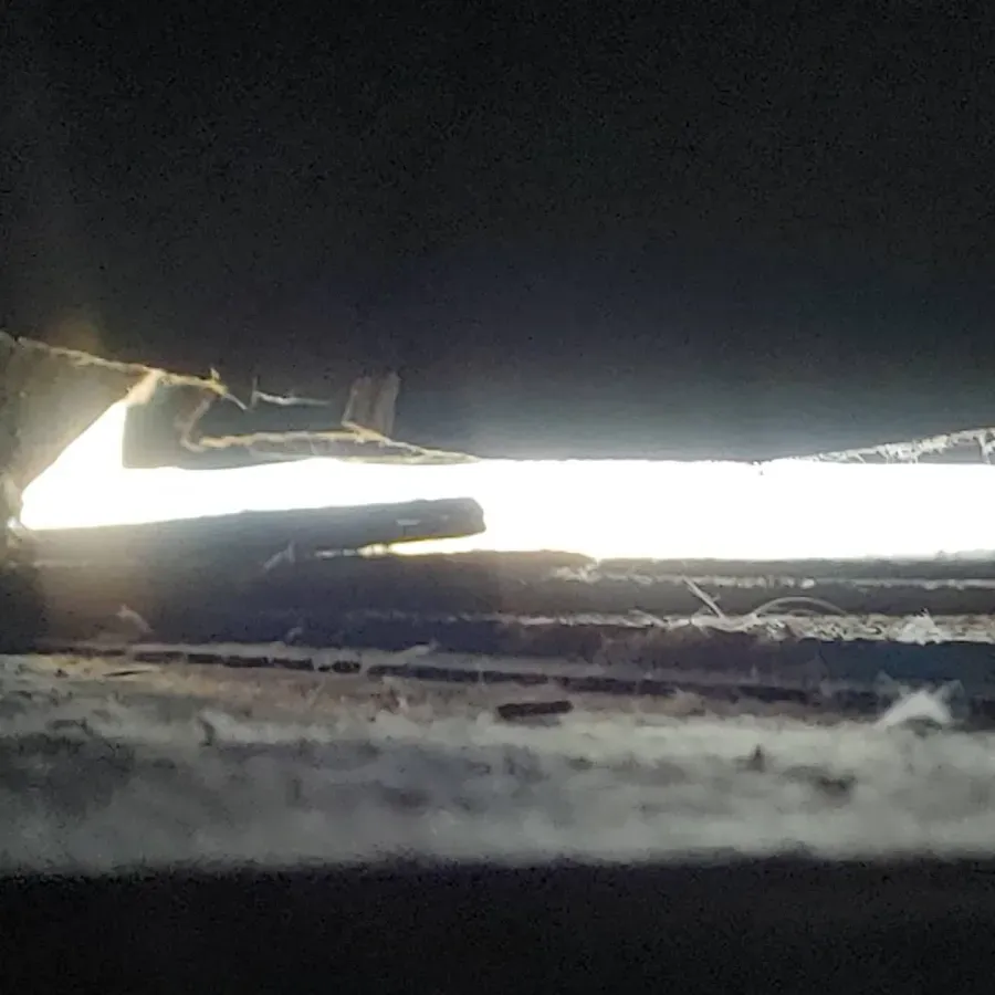 A light is shining through a hole in a wall.