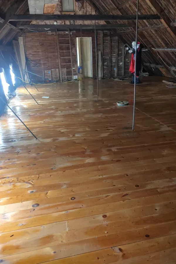 A room with a wooden floor and a mirror.