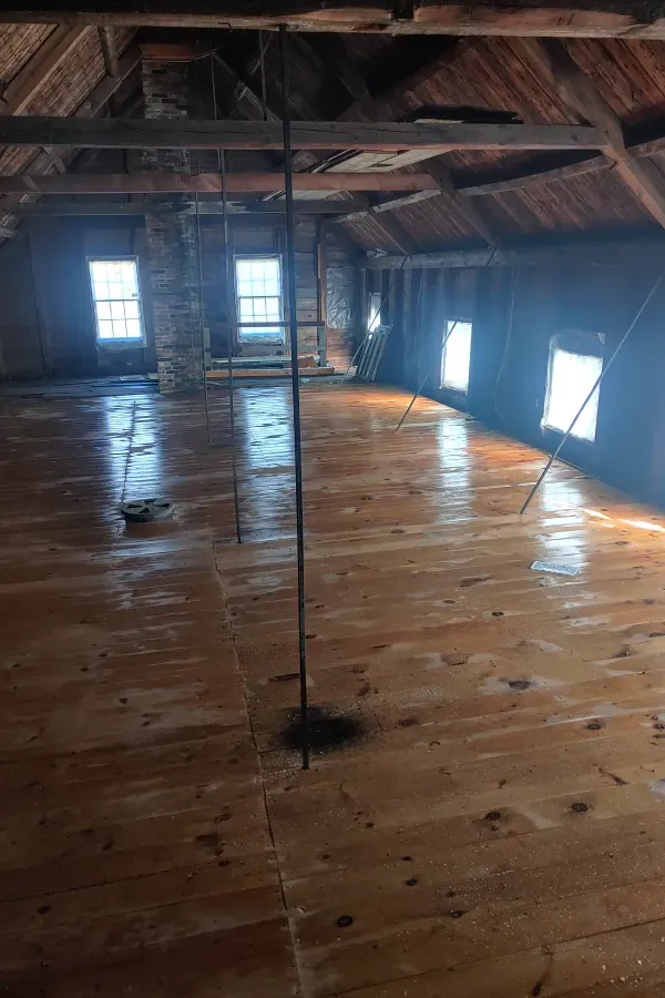 There is a wooden floor in the attic of a building.