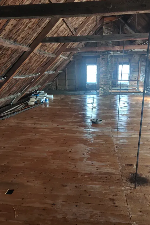 There is a wooden floor in the attic of a building.