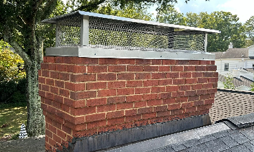 A brick chimney with a blue sky in the background.
