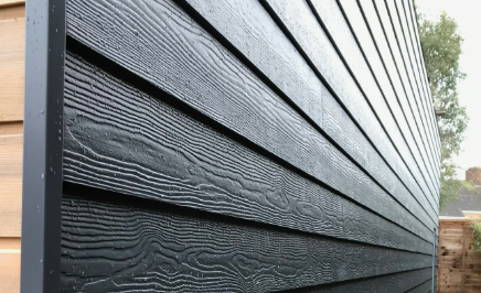 A close up of a black wooden siding on a house.