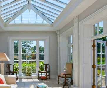 A living room with a glass roof and lots of windows