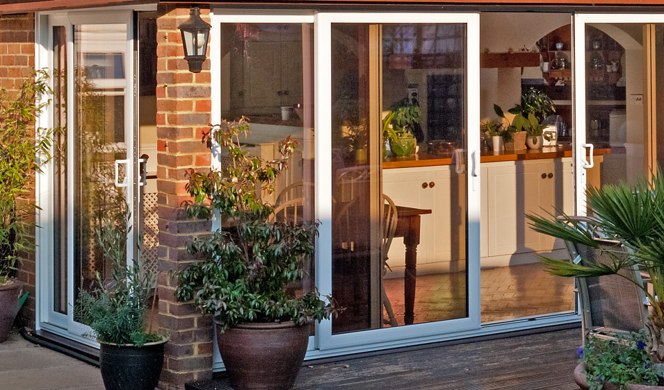 A house with a lot of windows and potted plants