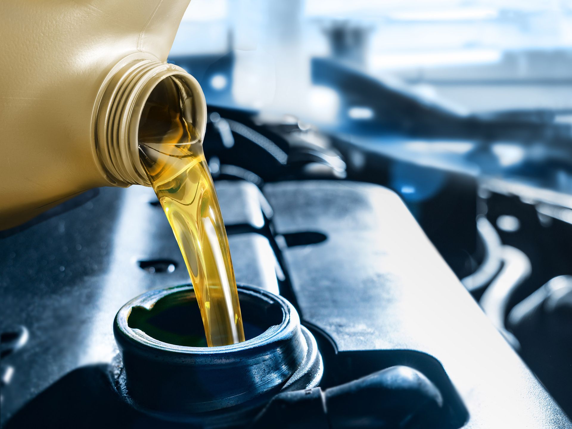Pouring oil from a yellow container into a car engine, highlighting maintenance.