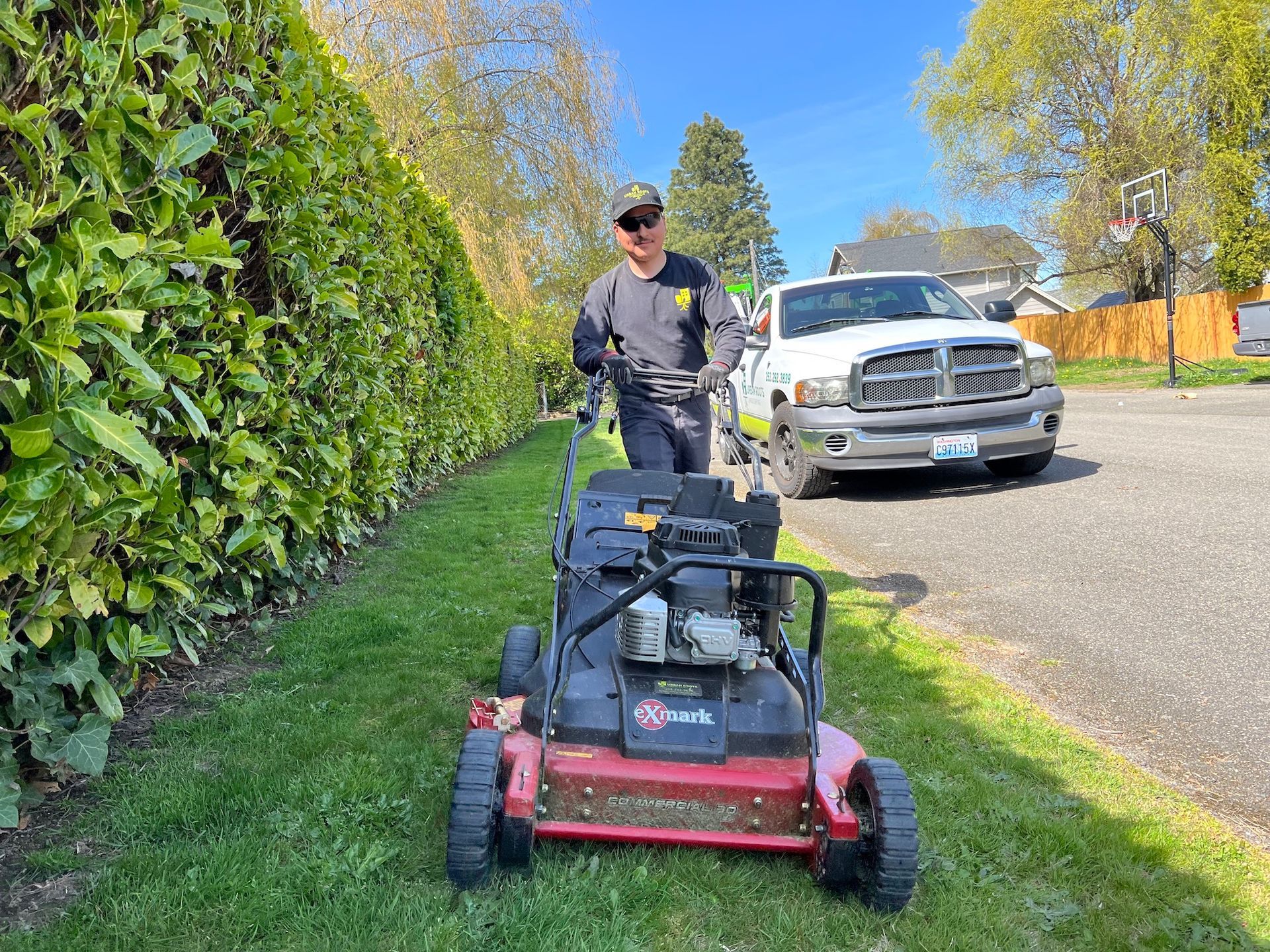 A man is mowing his lawn with a lawn mower.