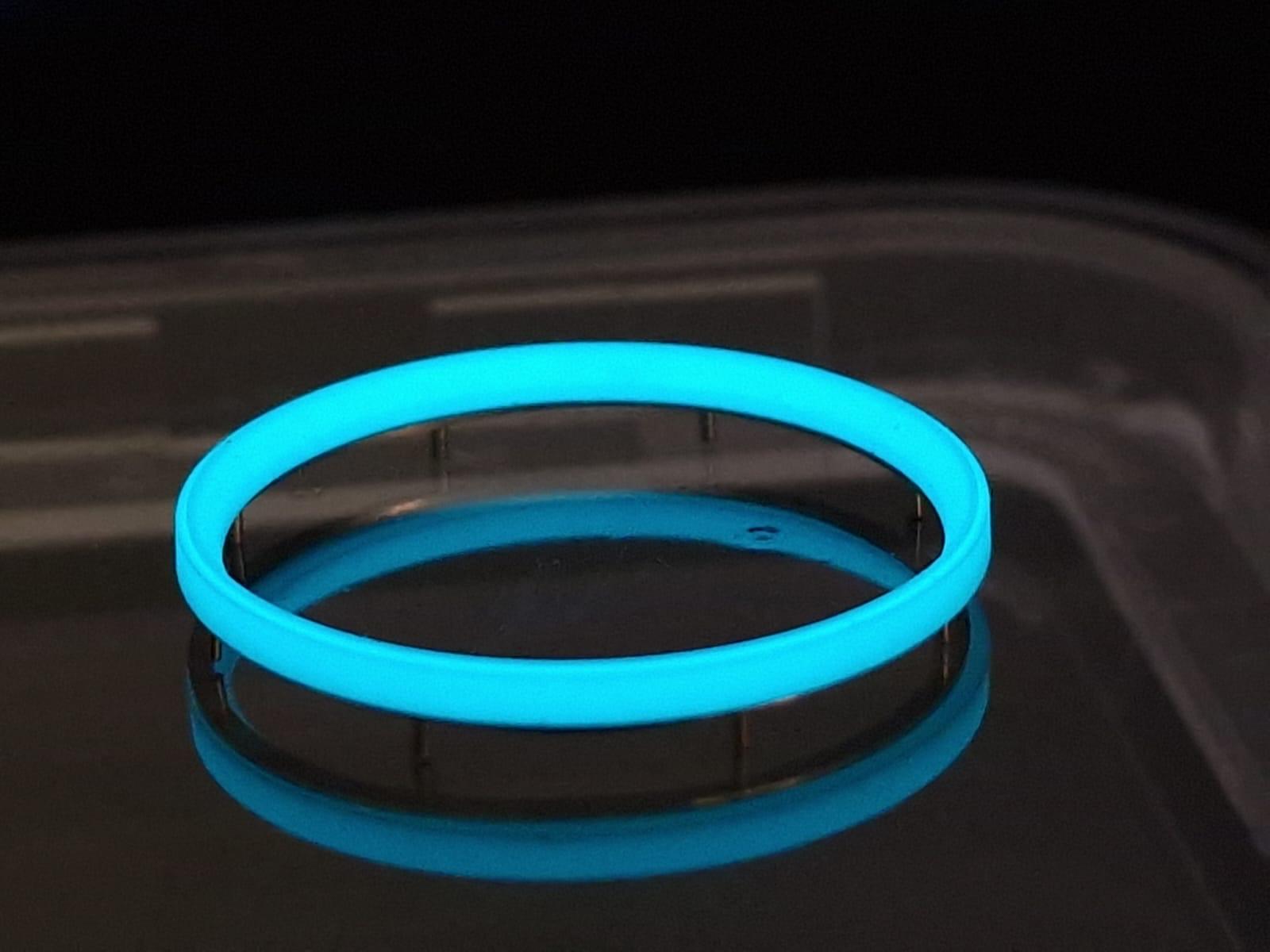 A glow in the dark bracelet is sitting on a table