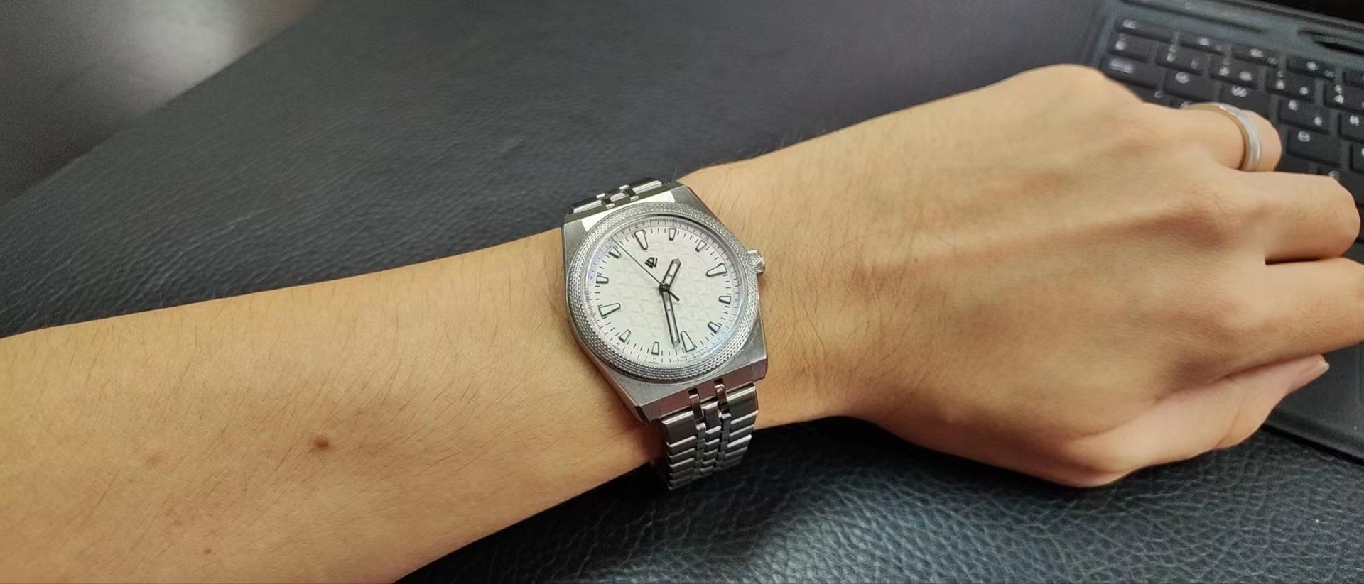 A person is wearing a silver watch on their wrist.