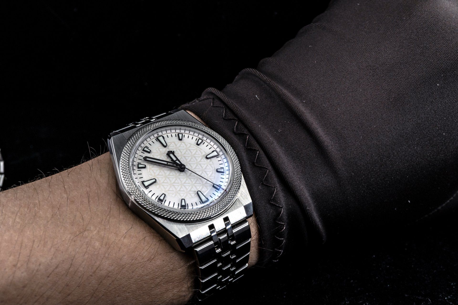 A man is wearing a silver watch on his wrist.