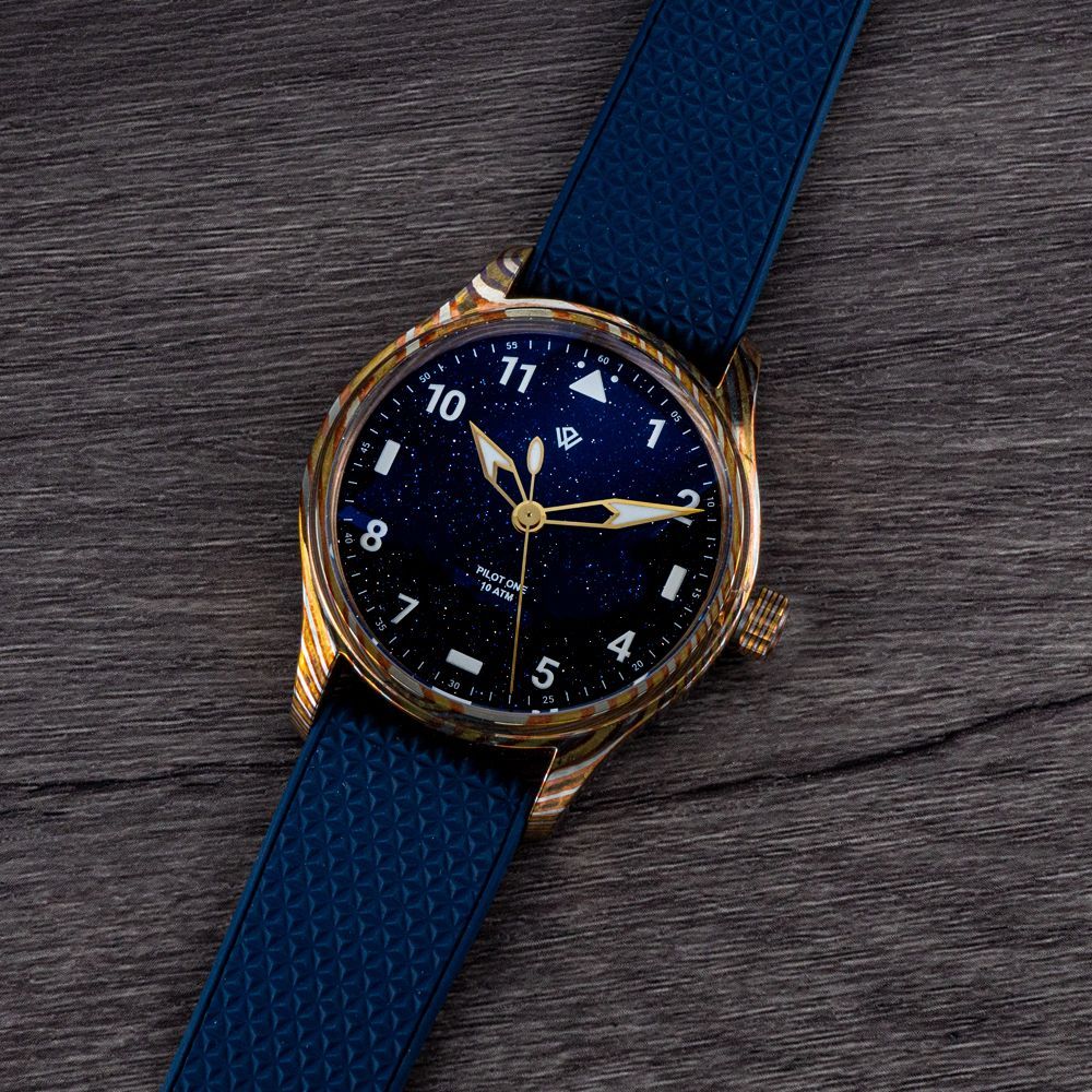 A watch with a pink face and a brown leather band on a black background.