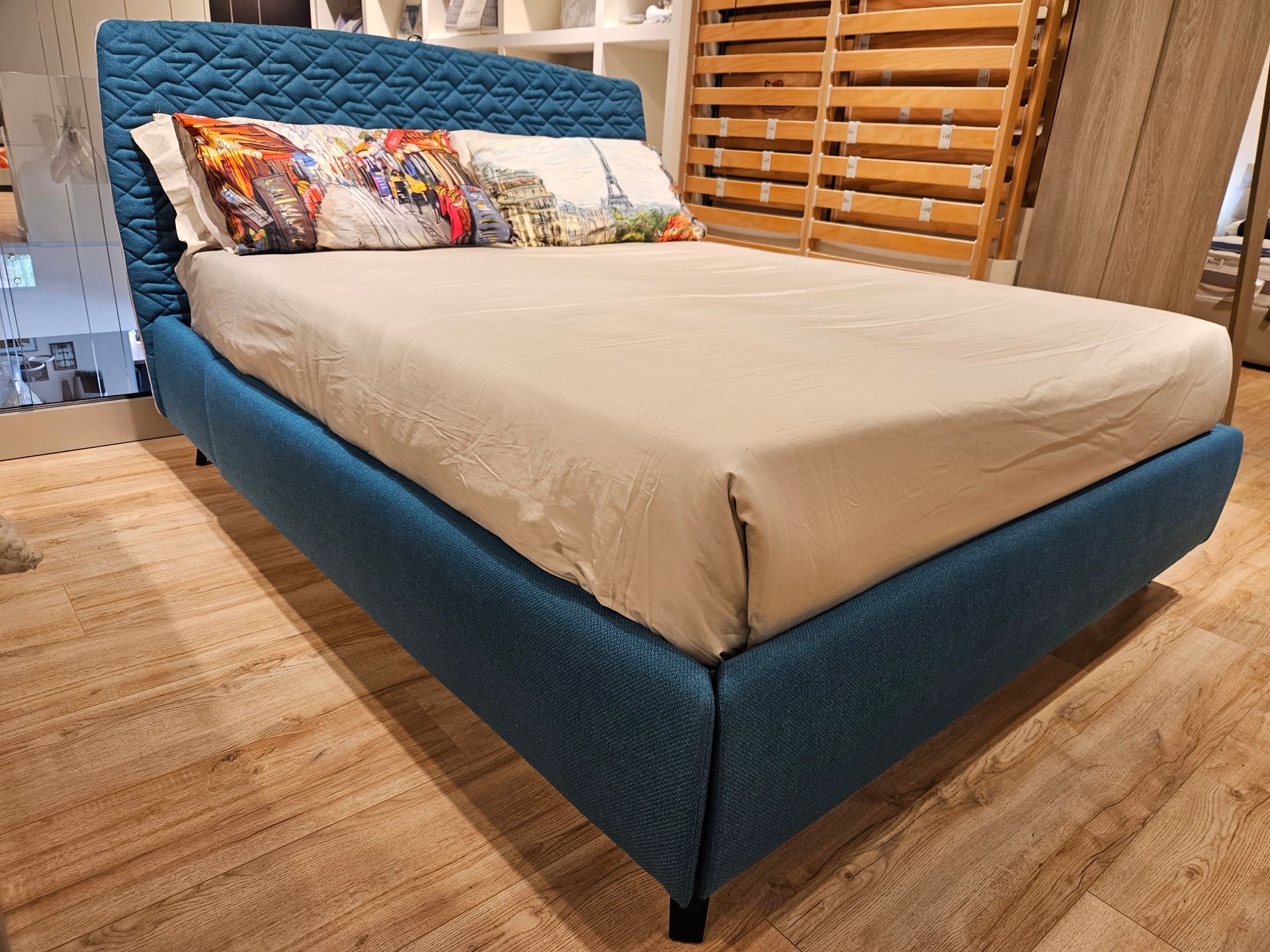 cornici con stampe appese, scrivania in legno e cassettiera