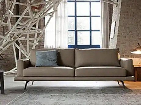 divano a due posti beige con piedi e cuscino grigio