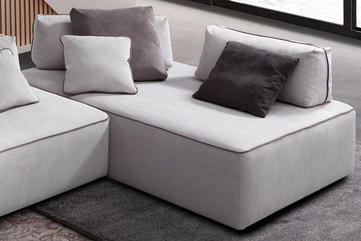 zona angolare di un divano bianco sporco con cuscini