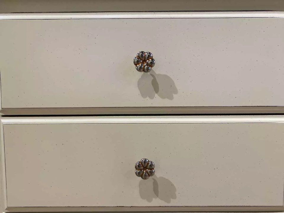 pomelli a forma di fiore di un comò bianco