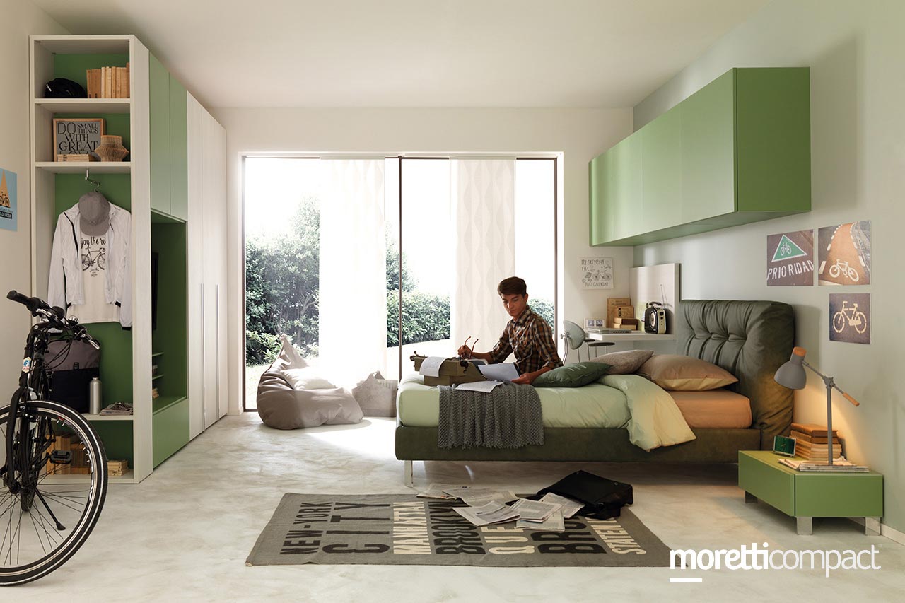 ragazzo seduto sul letto nella sua cameretta sui toni del verde