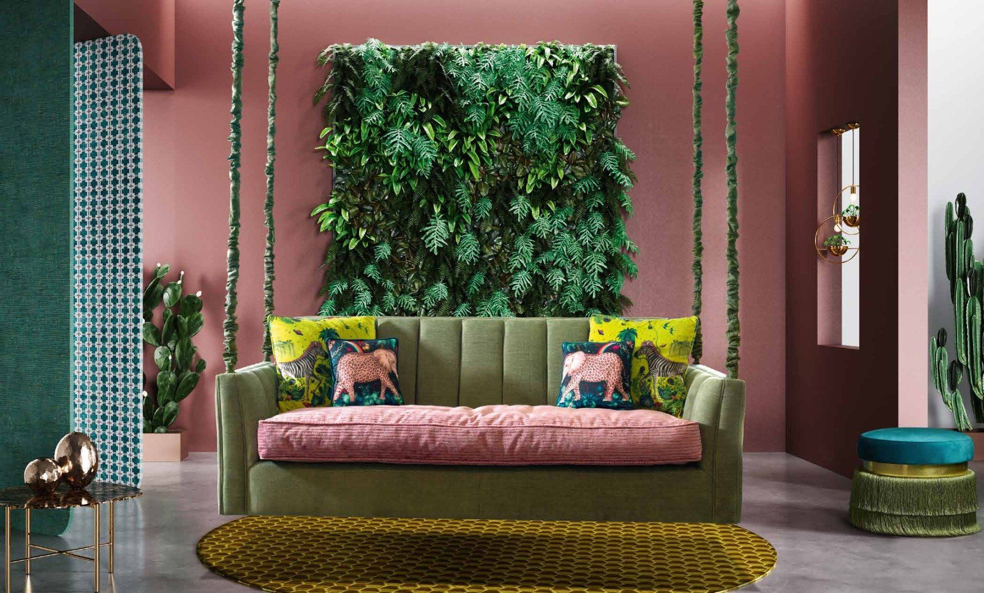 divano verde a due posti con copri cuscini in rosa