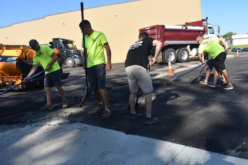 A group of men are working on a parking lot.