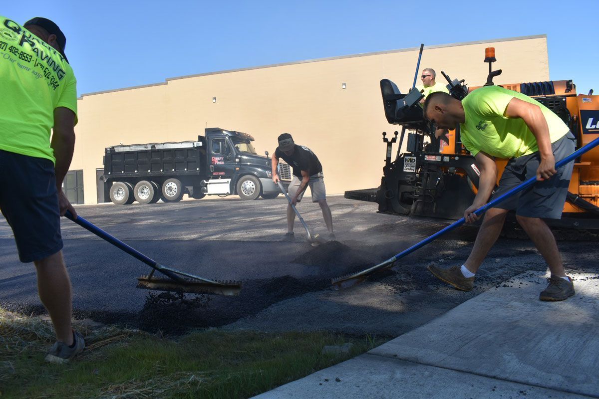 A group of men are working on a driveway.