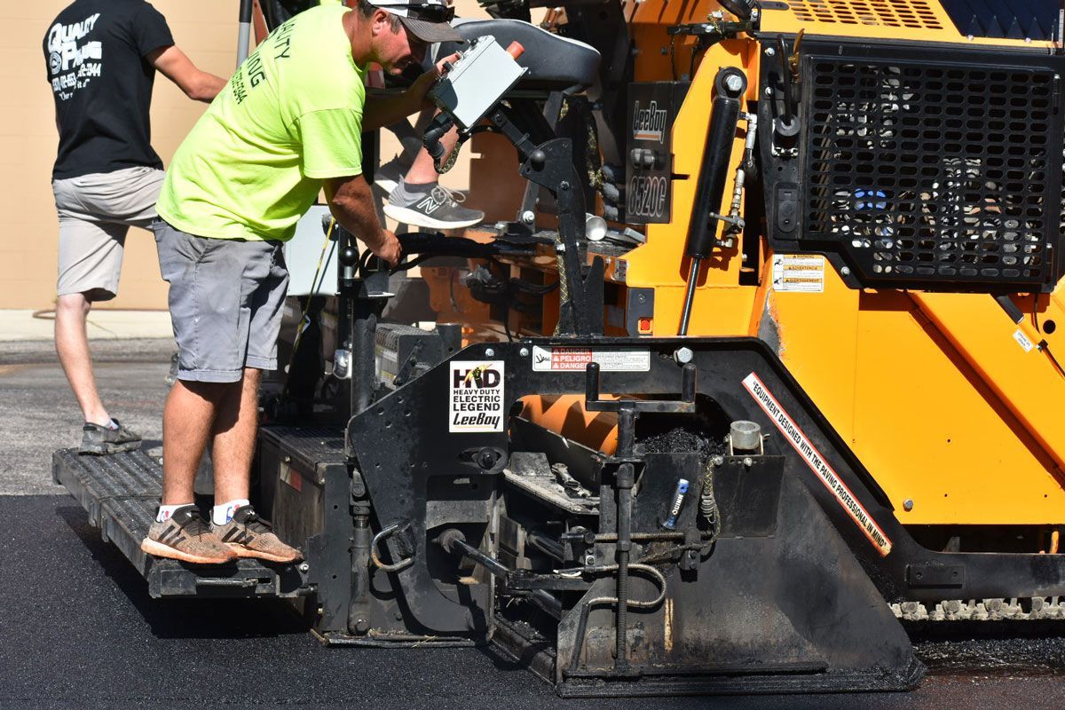 A man in a green shirt is working on a machine.