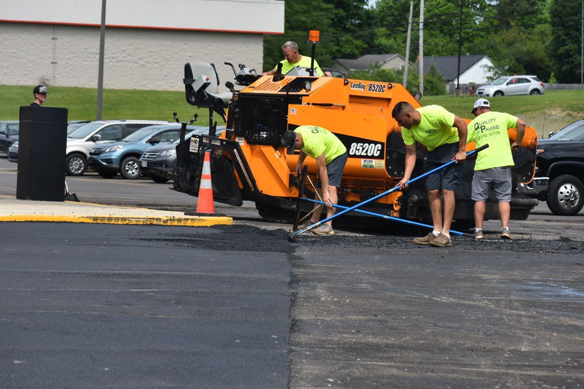 A group of men are working on a parking lot.